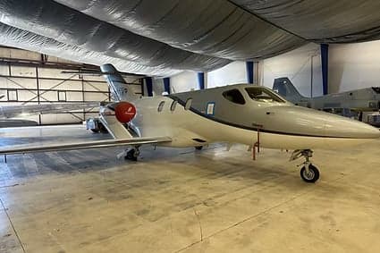 Side view of a HondaJet inside a hangar.