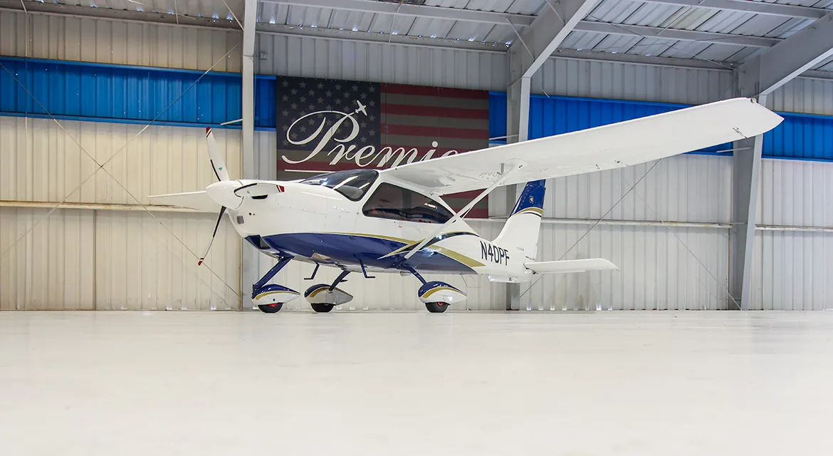 A Techman aircraft with registration N40PF is parked in a hangar with a Premier Aircraft banner in the background.