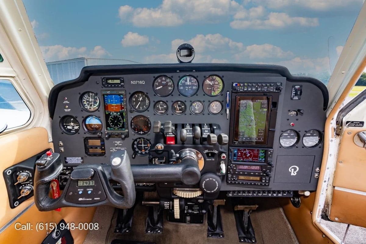 The cockpit of an aircraft, featuring a complex instrument panel with analog gauges, digital displays, and a control yoke.