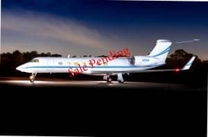 A white jet aircraft with blue stripes is parked on the tarmac at dusk with the words Sale Pending overlaid.