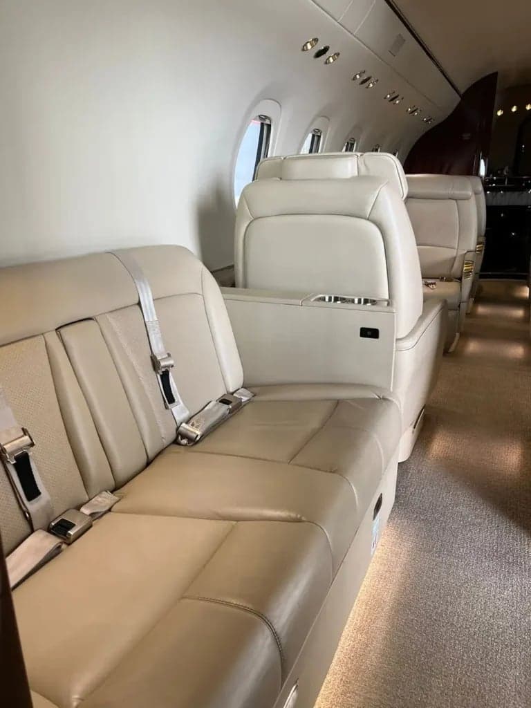 A view of the tan leather seating along the side of the aircraft cabin.