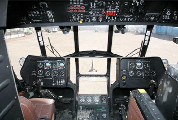 The cockpit of a helicopter with various instruments and controls.