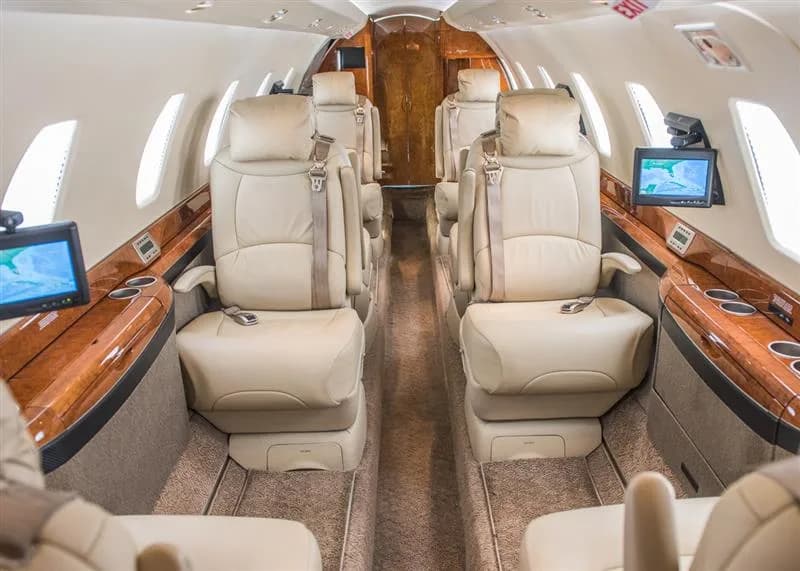 The aircraft's interior features leather seats and wood accents.