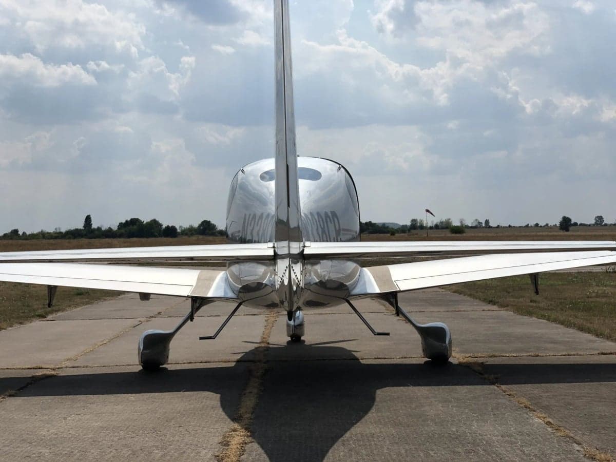 A Cirrus SR22T with registration N338CP is parked on the tarmac.