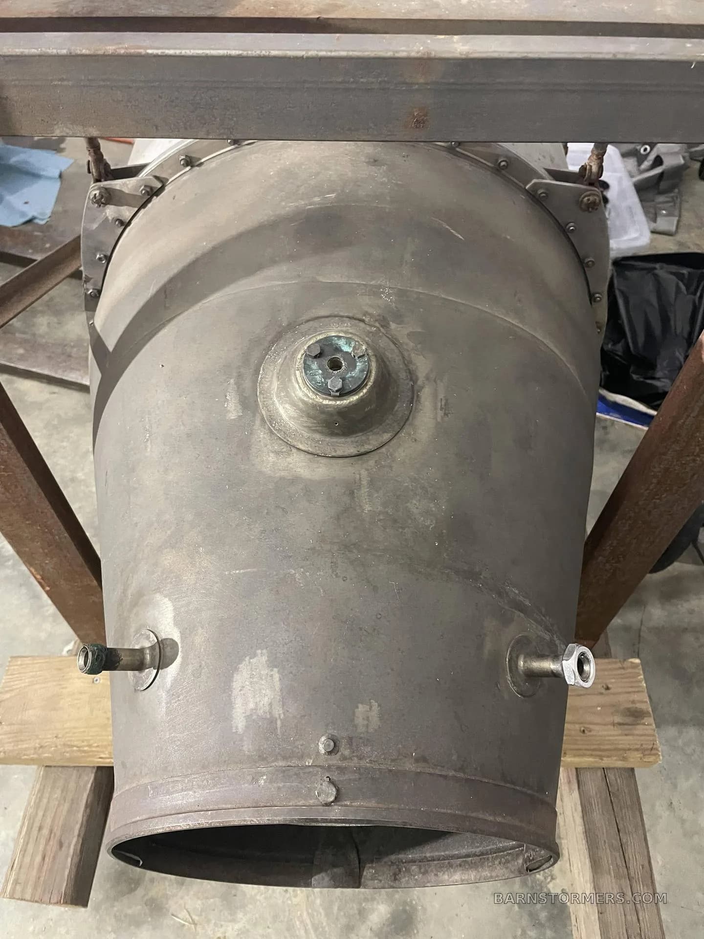 The rear section of a jet engine, showing the exhaust cone and various ports.