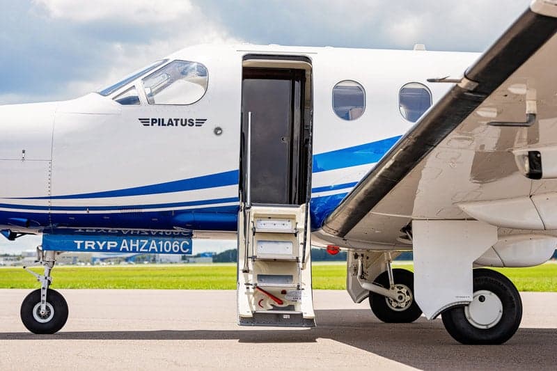 Close-up of the open door and steps of a Pilatus PC-12 aircraft.