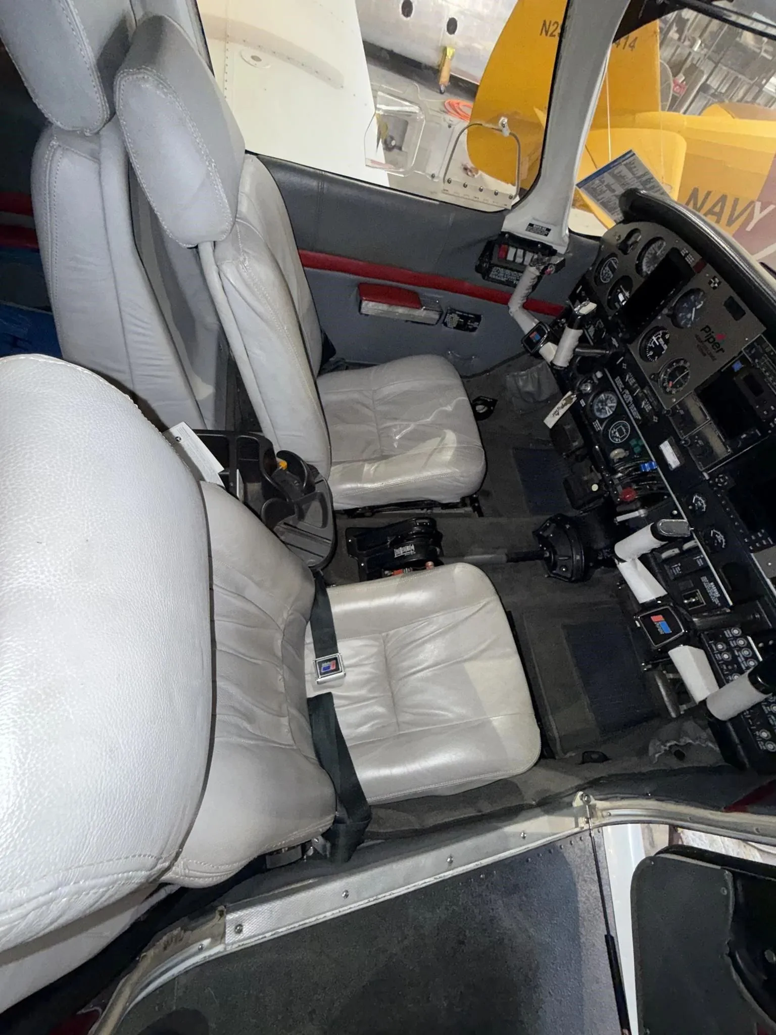 The front cabin seats and a partial view of the cockpit in the Piper Lance II aircraft.