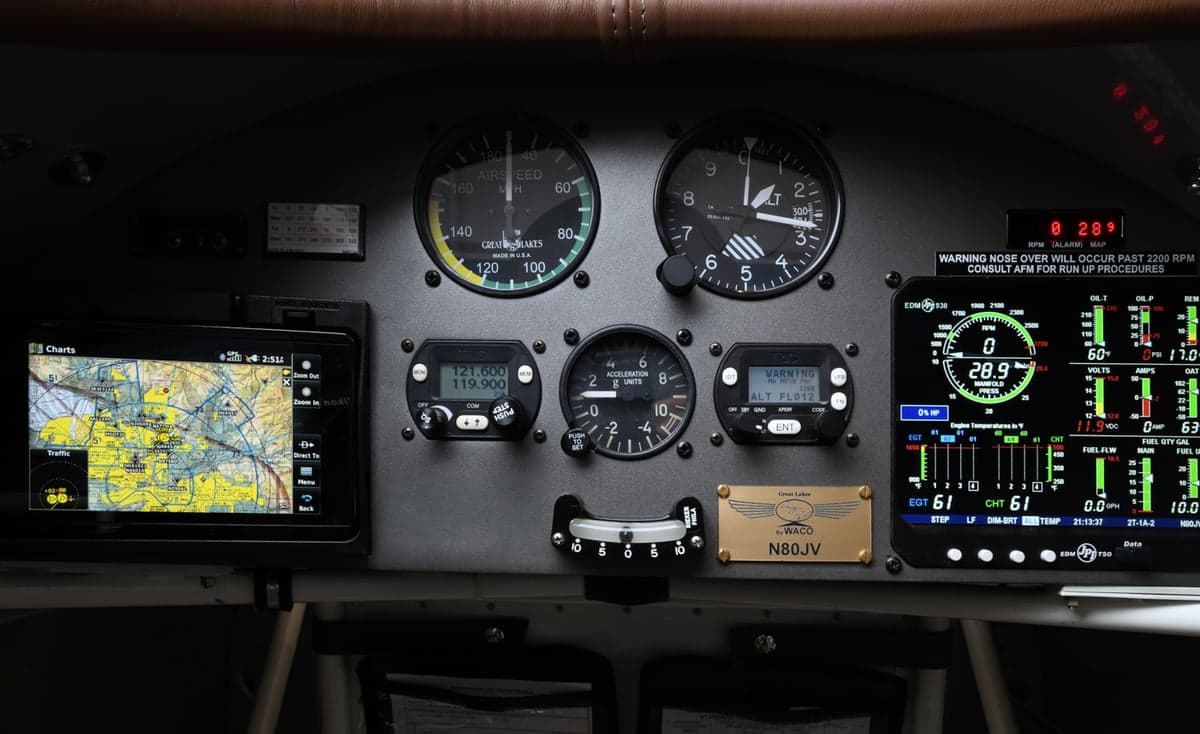 The instrument panel of a biplane, featuring various gauges and displays.