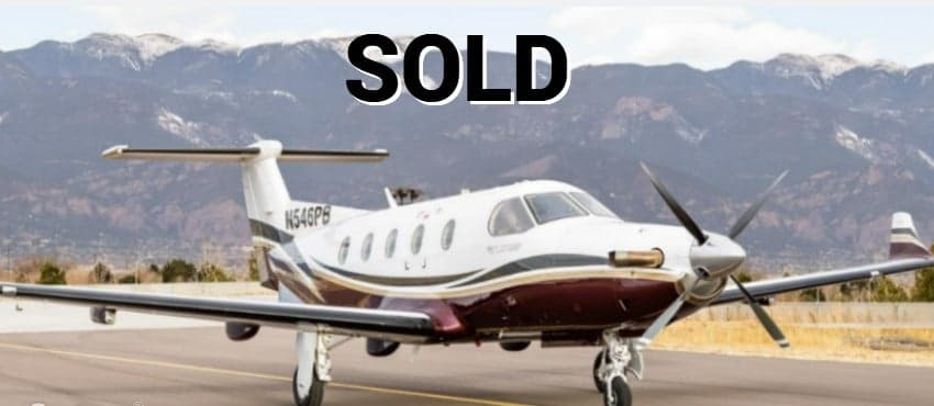 Pilatus PC-12 on the runway with mountains in the background, marked as SOLD.
