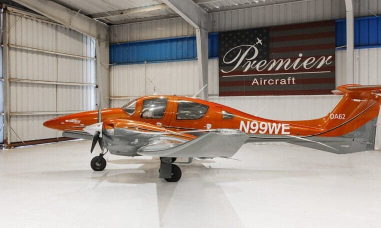 A Diamond DA62 aircraft with registration N99WE is parked in a hangar.