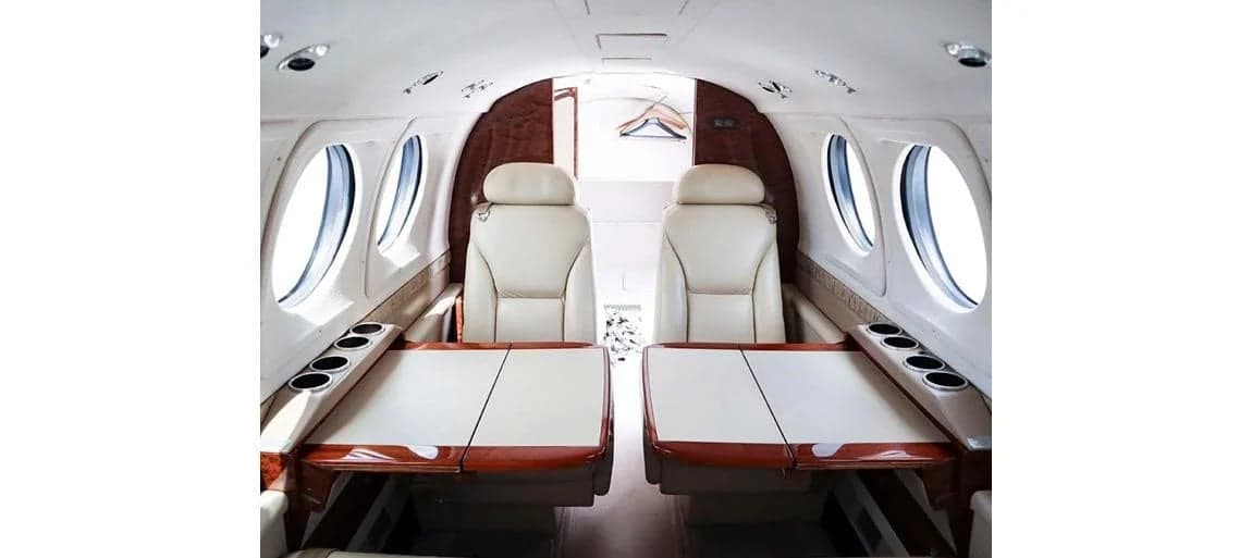 View of the aircraft cabin with two seats and tables.