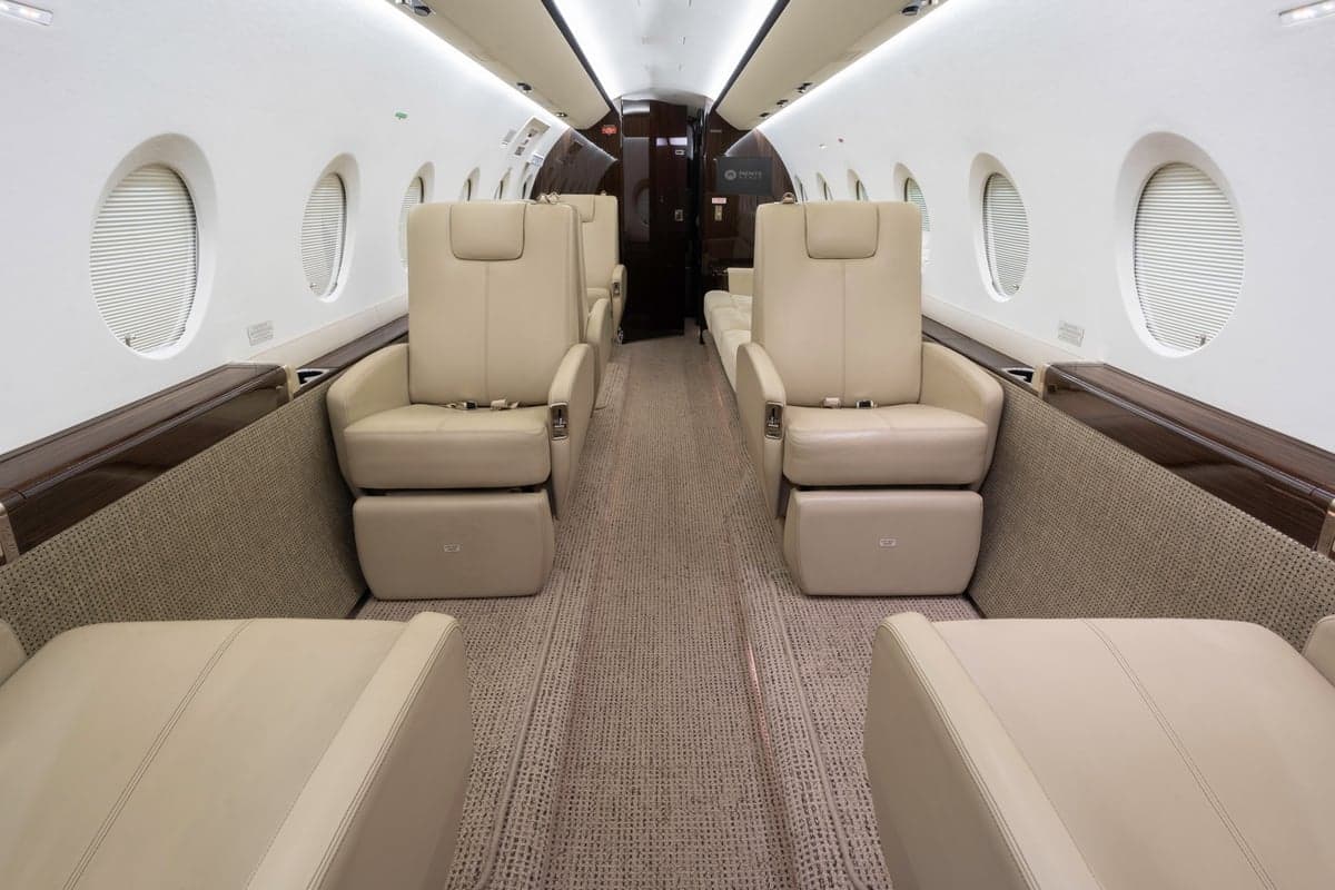 Interior view of the Gulfstream jet cabin with leather seats and carpeted floor.