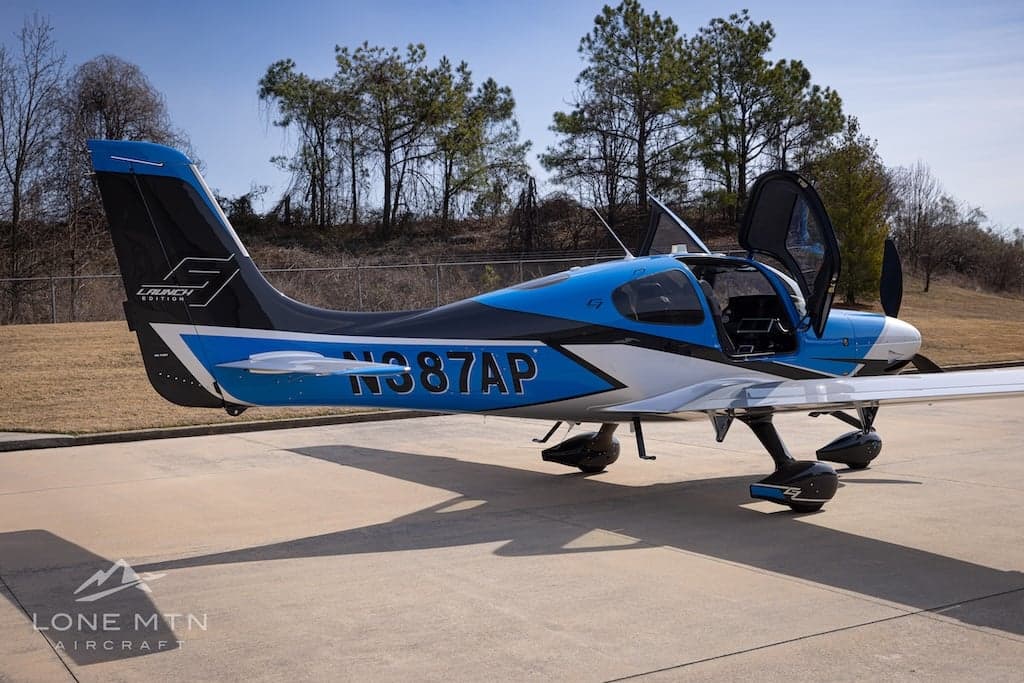 Cirrus SR22T with blue and silver paint scheme on the ramp with doors open.
