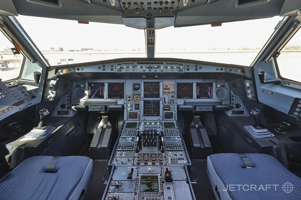 A wide-angle view of the modern, digital cockpit of an Airbus A340-300.