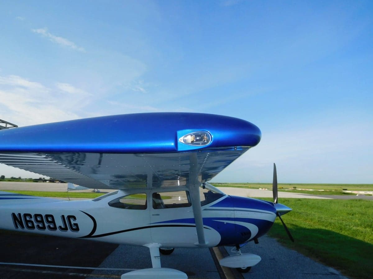 Close-up of the wing and cowl of the N699JG Cessna aircraft.