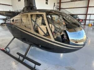 A side view of the Robinson R66 helicopter shows the cockpit and cabin area.