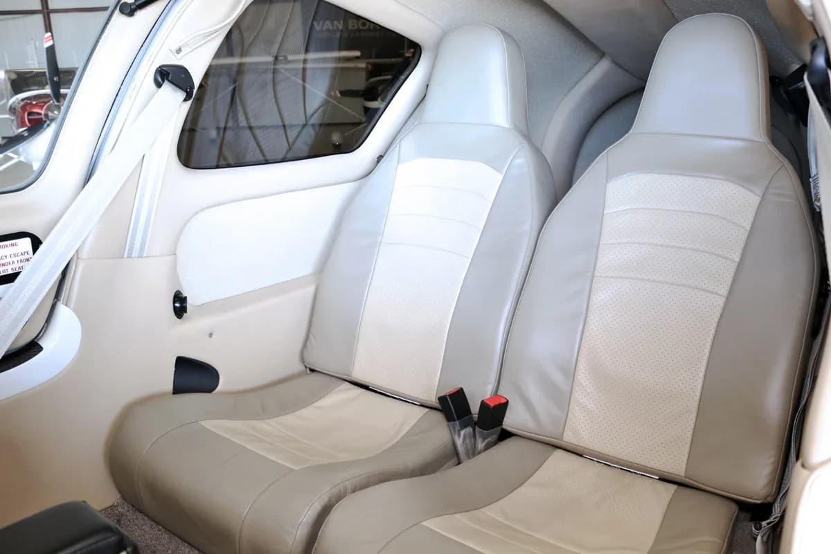 The light beige and tan passenger seats in the interior cabin of the aircraft.