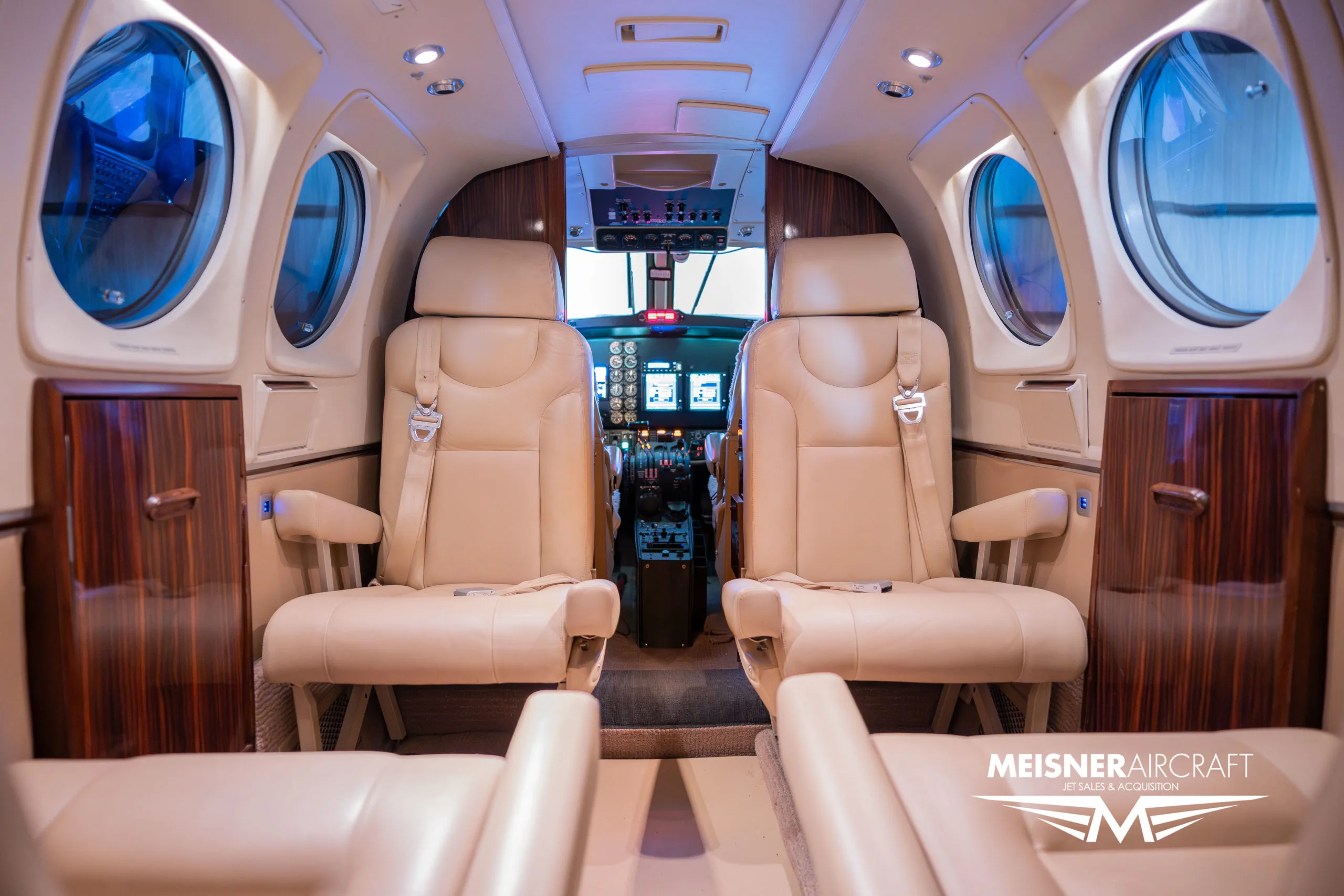 The beige leather interior cabin of a Beechcraft King Air, looking forward towards the cockpit.