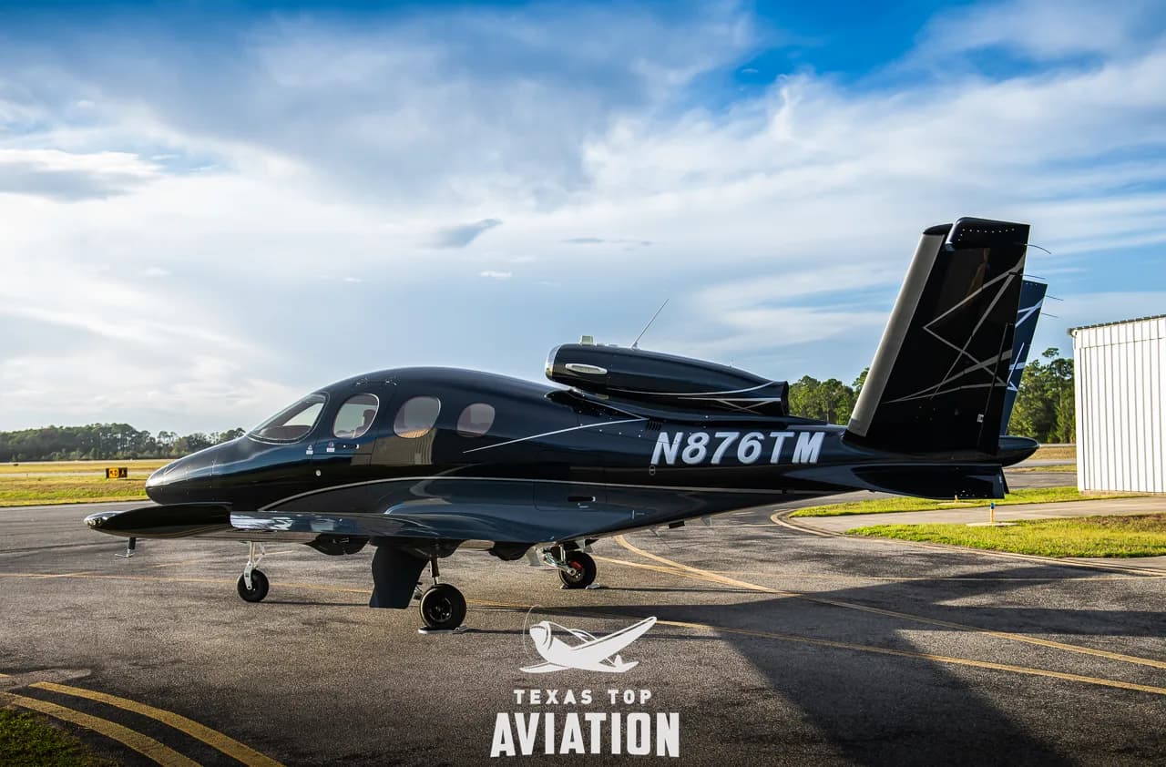 A black Cirrus Vision Jet is parked on the tarmac.