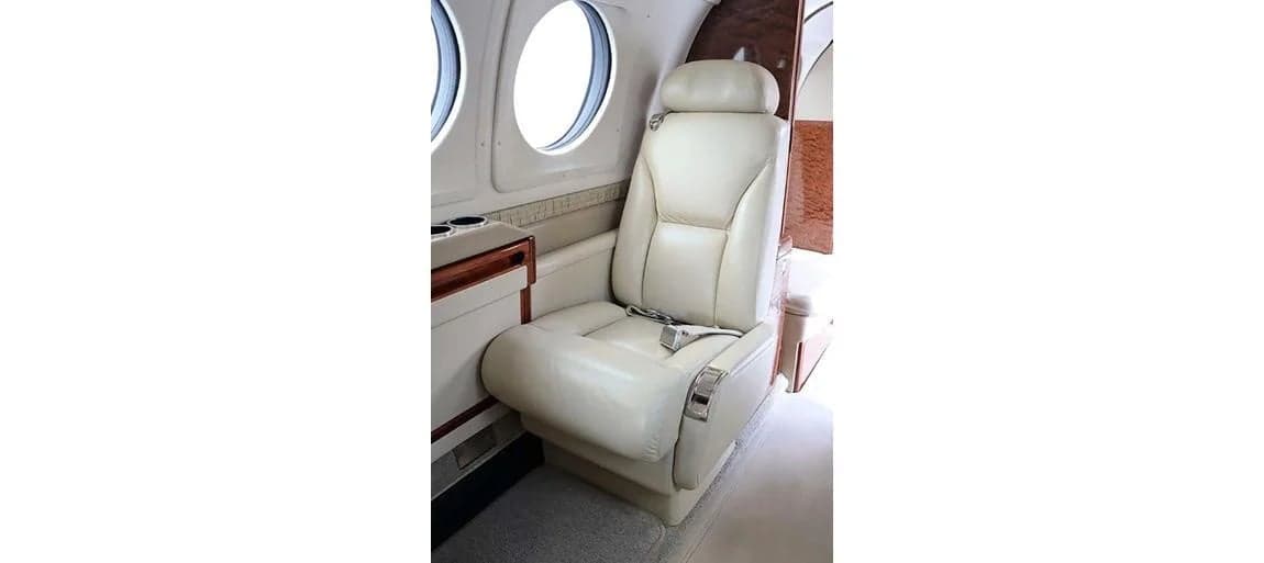 A single cream-colored leather seat inside the aircraft cabin.