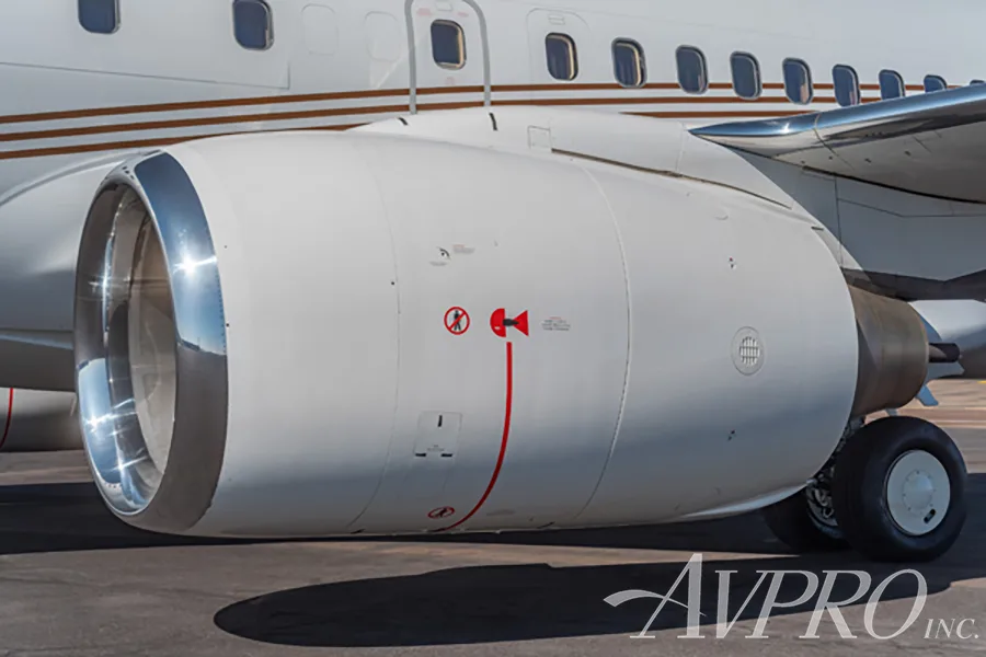A close-up view of the white engine nacelle with a polished intake of a Boeing 737 business jet.