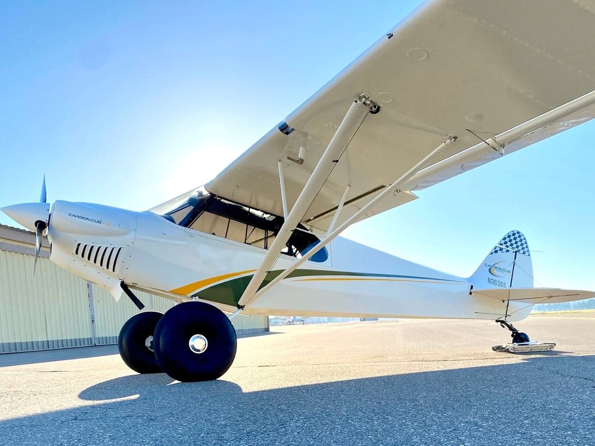 Side view of a Carbon Cub FX-3 aircraft with tail number N363SS parked on the tarmac.