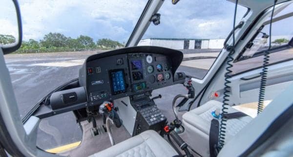 The cockpit of the Eurocopter AS350B3 Ecureuil features a modern instrument panel and white seats.