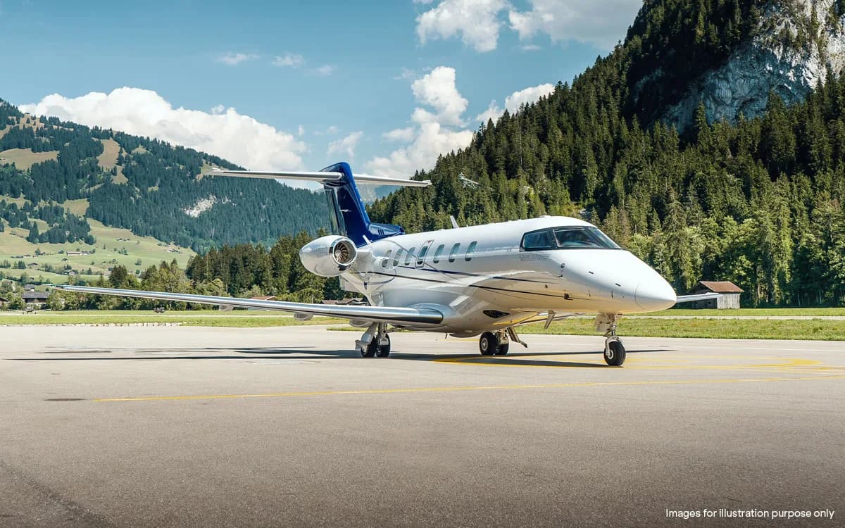 Pilatus PC-24 on the tarmac with mountains in the background.