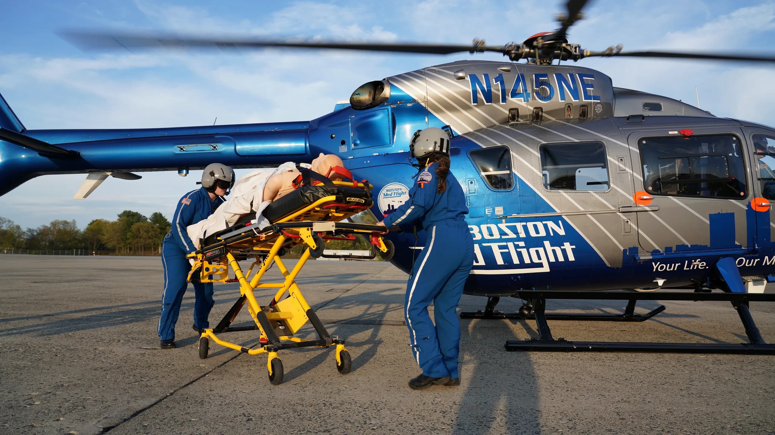 A Boston MedFlight helicopter with medical personnel and a patient on a stretcher.