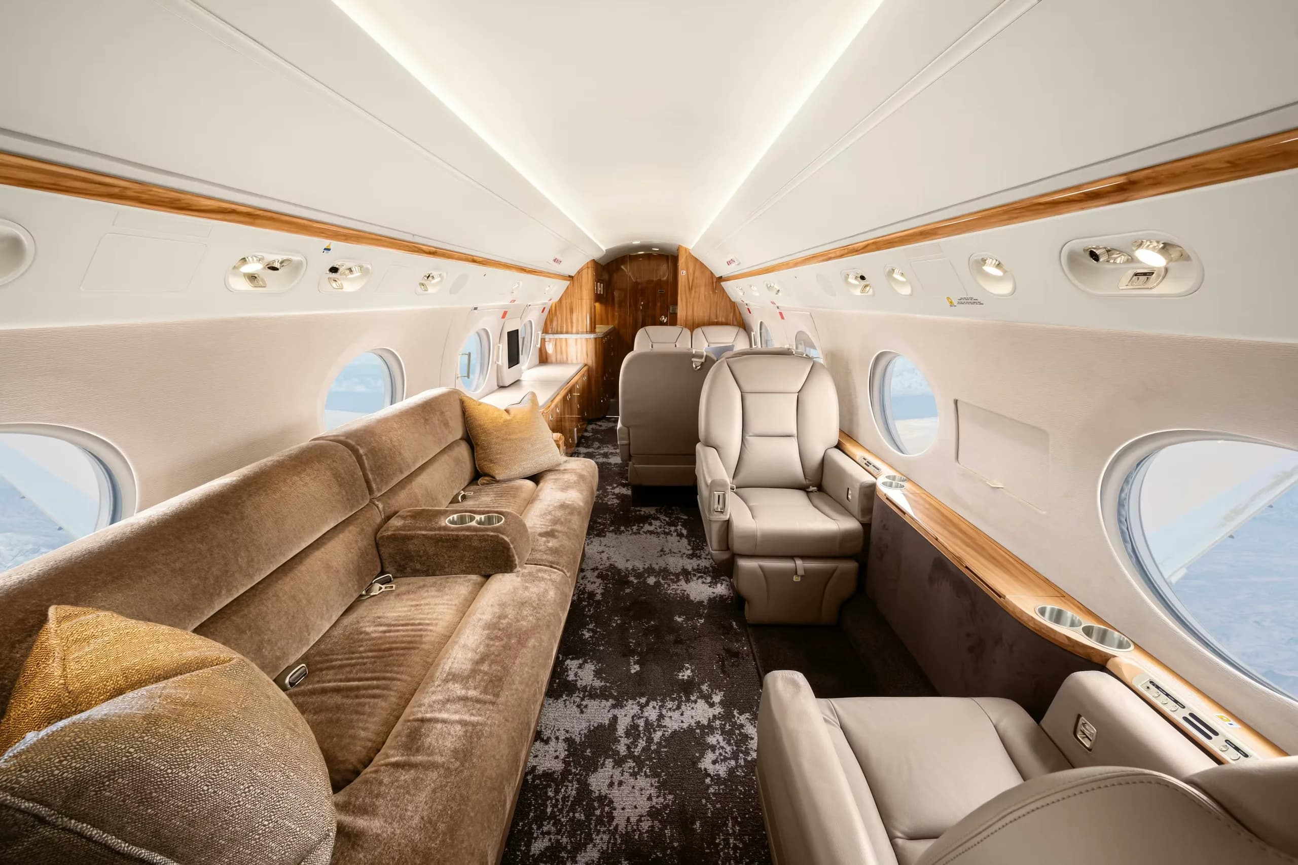Interior view of the aircraft cabin with a couch and leather seats.