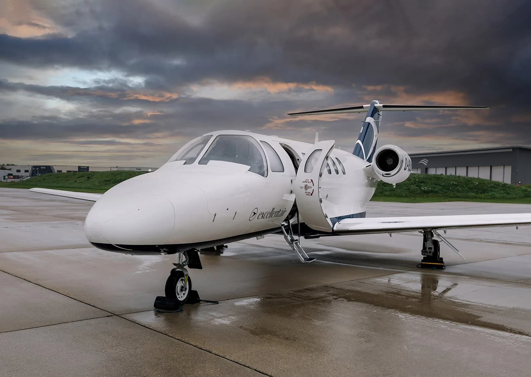 Front view of a Cessna Citation CJ2 aircraft with registration D-ISUN parked on the tarmac with the entry door open.