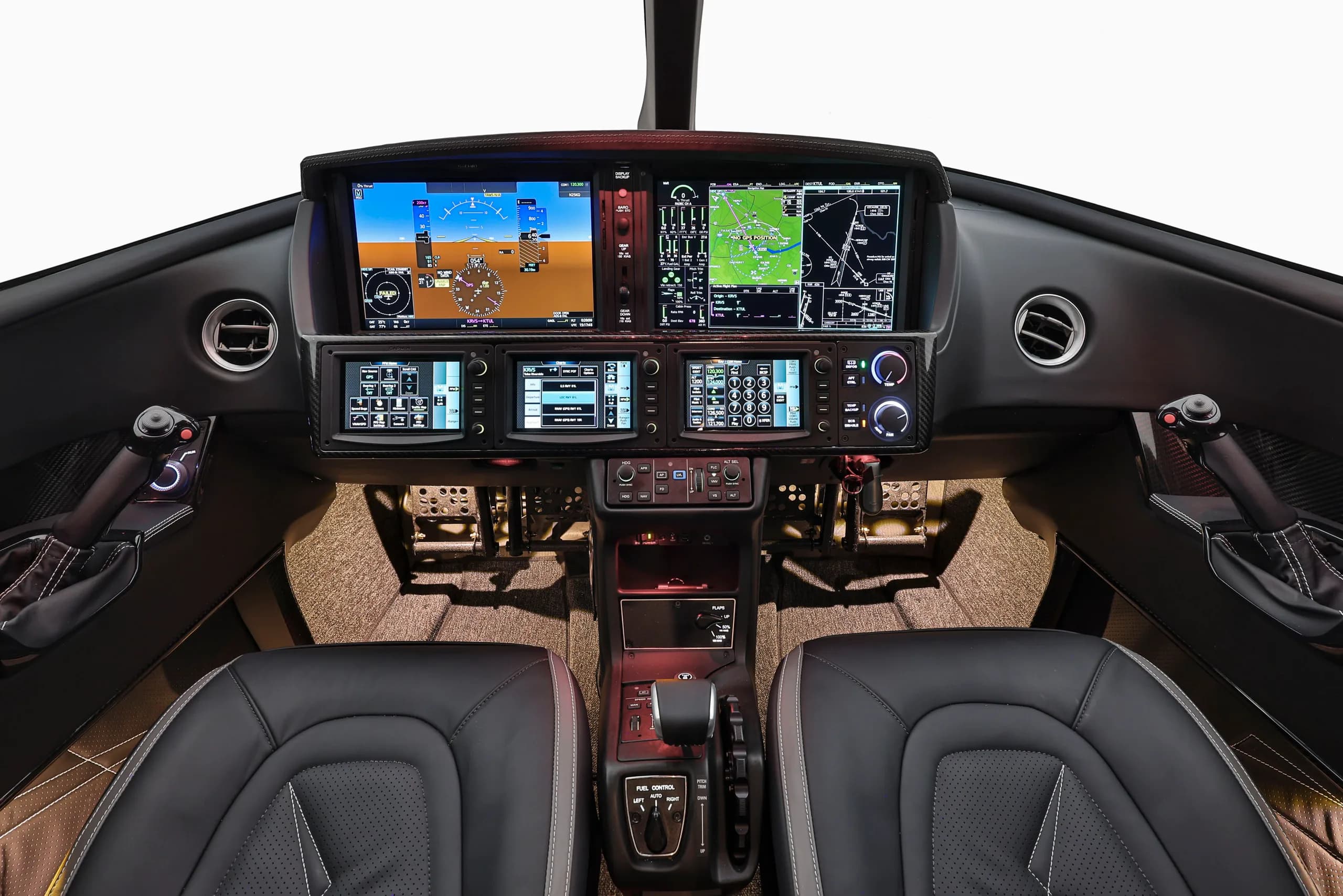 The cockpit of a modern jet displays multiple large digital screens and a central control panel.