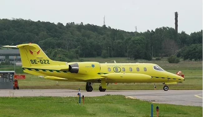 Yellow Scandinavian Air Ambulance jet on the ground.