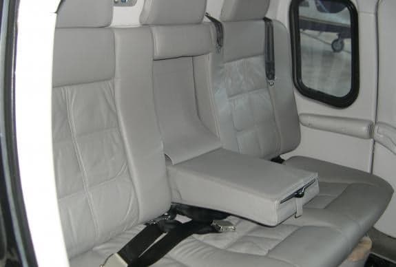 A view of the interior of the aircraft with gray leather seats and a center armrest.