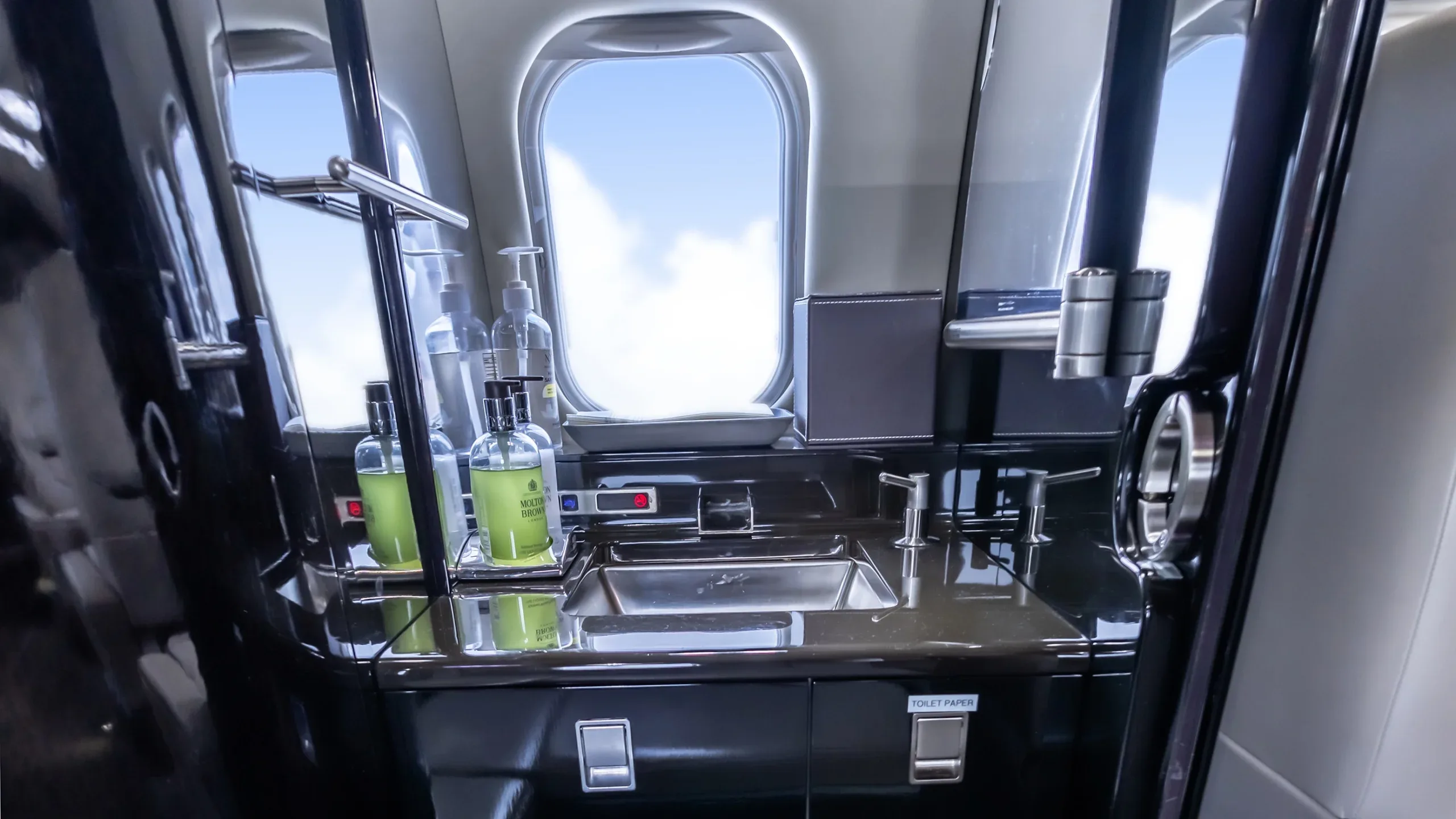 View of the aircraft lavatory with sink and toiletries.