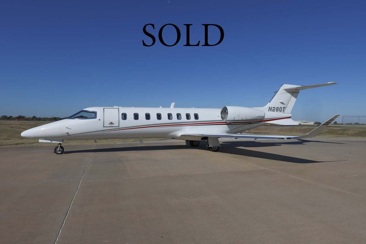 Learjet 45XR aircraft N28QT on the ramp with SOLD overlay.
