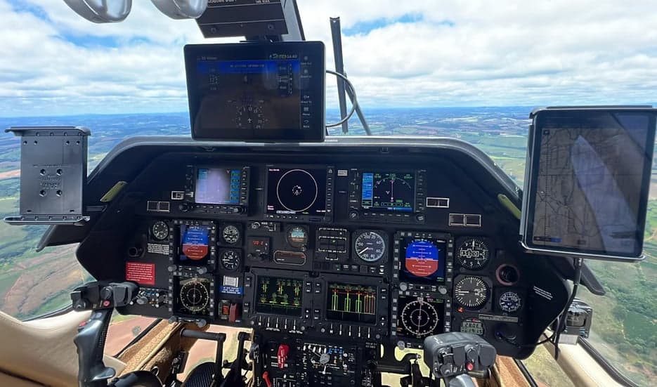 Helicopter cockpit with multiple displays and controls.
