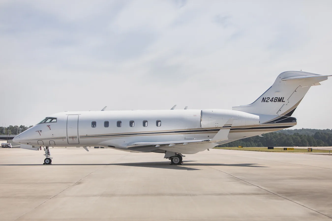 Side view of the Challenger 300 aircraft with registration N248ML on the tarmac.