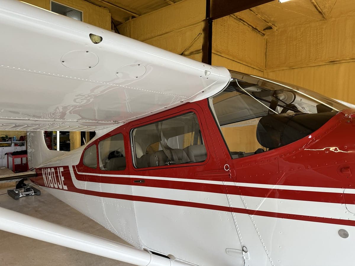 View of the cockpit and red and white paint scheme of N180JE.
