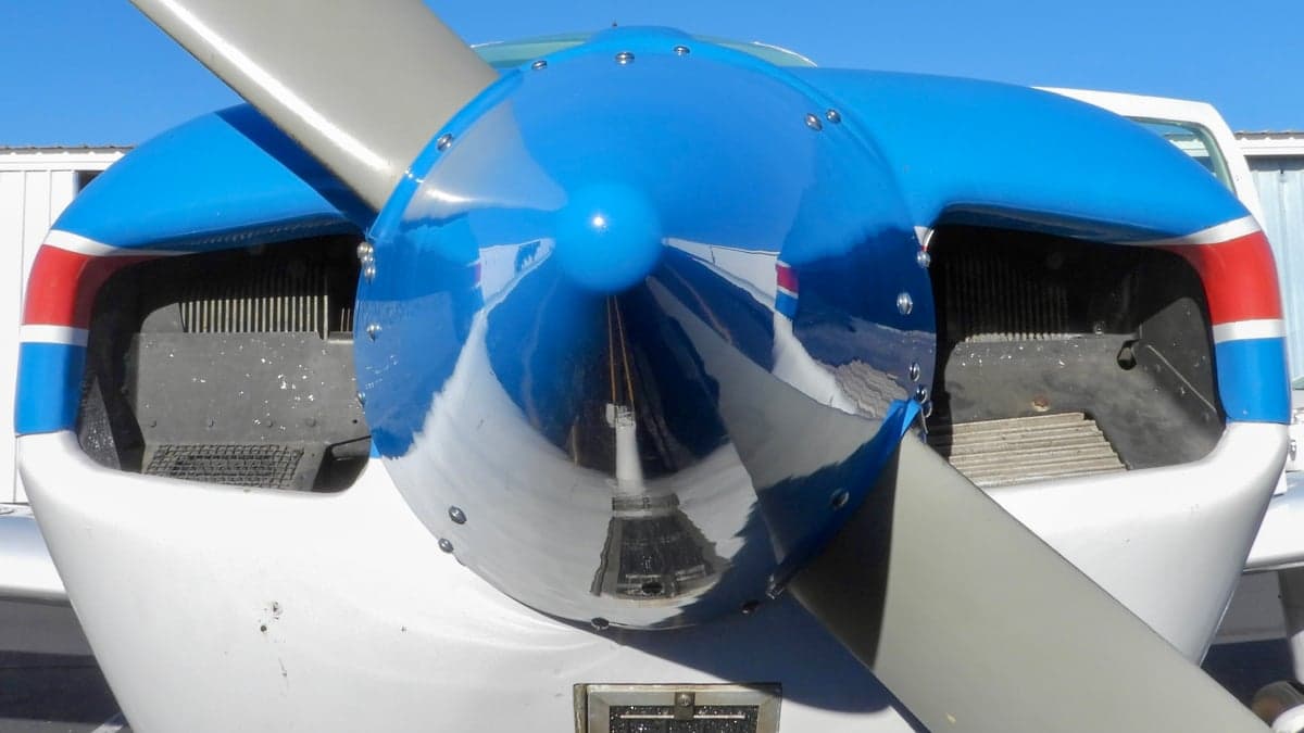 Close-up of the propeller and blue spinner of a Piper PA-28-140 Cherokee.
