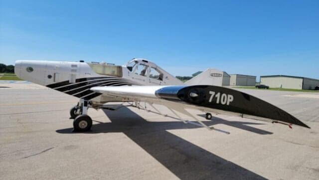 Full left side view of a white Thrush agricultural aircraft with black stripes and "710P" on the wingtip.
