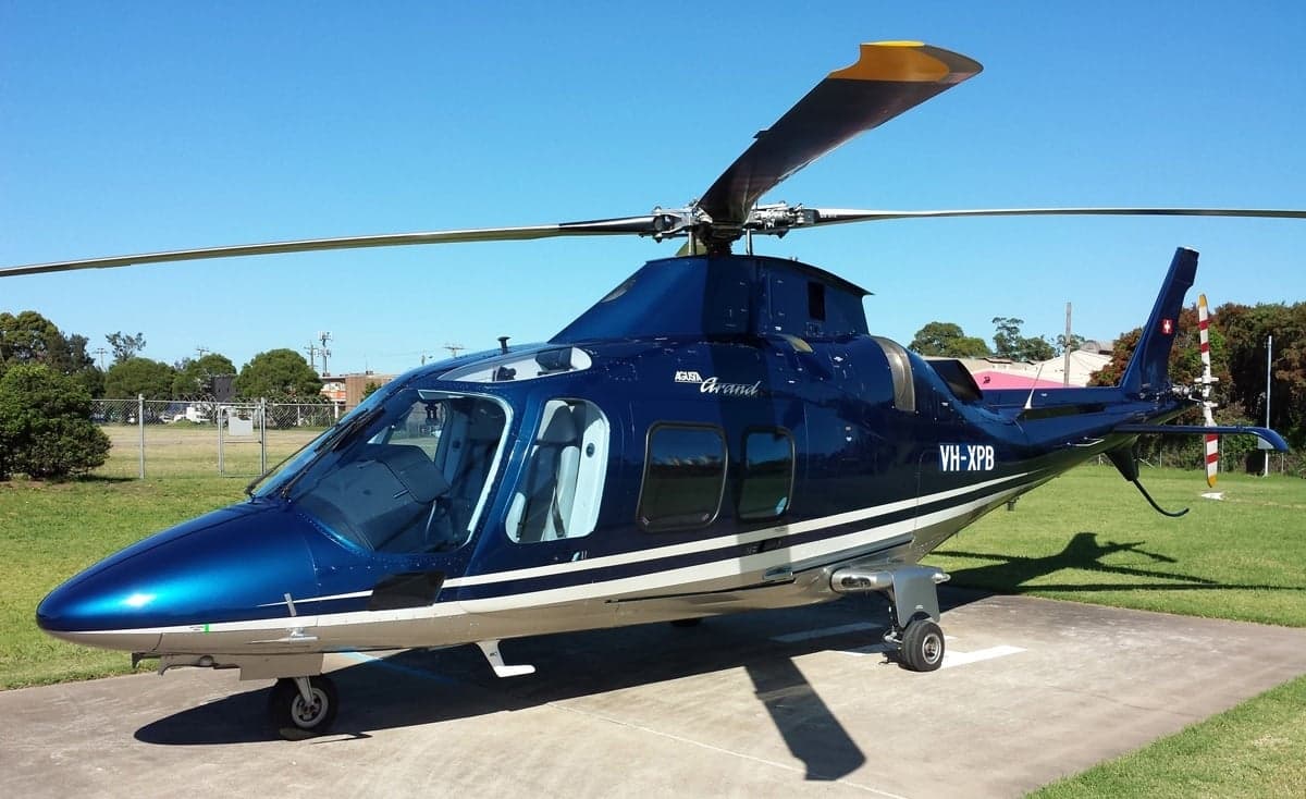 A blue Agusta Grand helicopter on a black background.