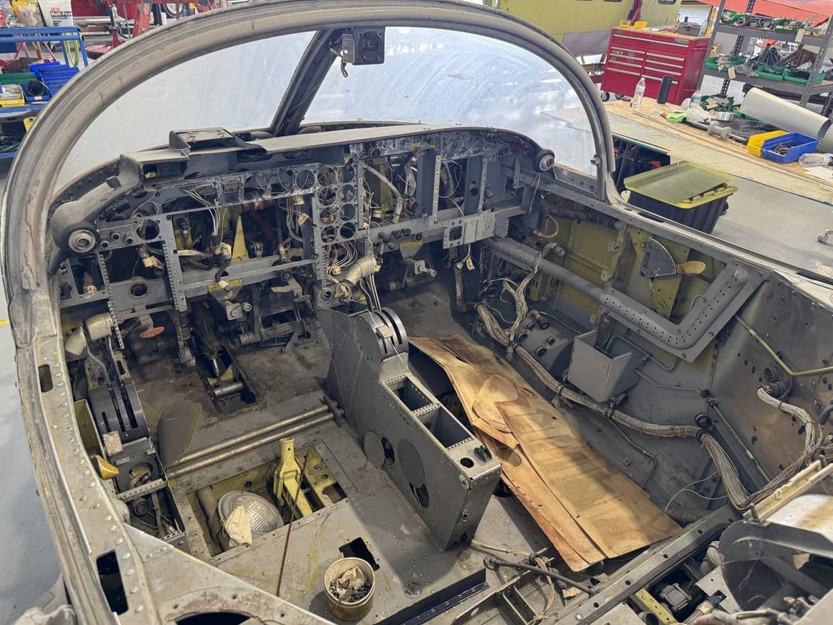 The cockpit of an aircraft undergoing restoration, showing the instrument panel and controls.