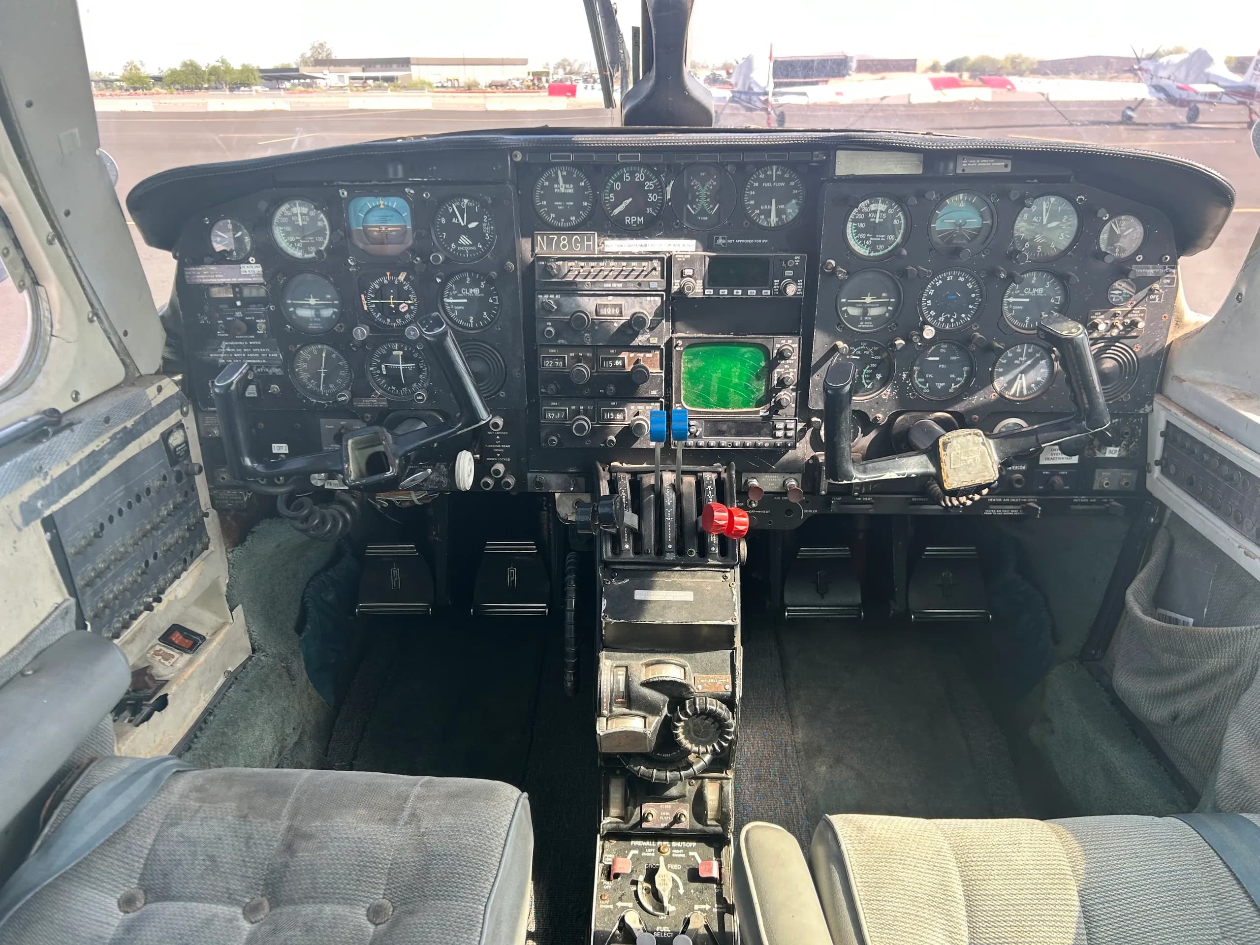 A wide view of the cockpit of aircraft N78GH, showing the instrument panel, controls, and pilot seats.