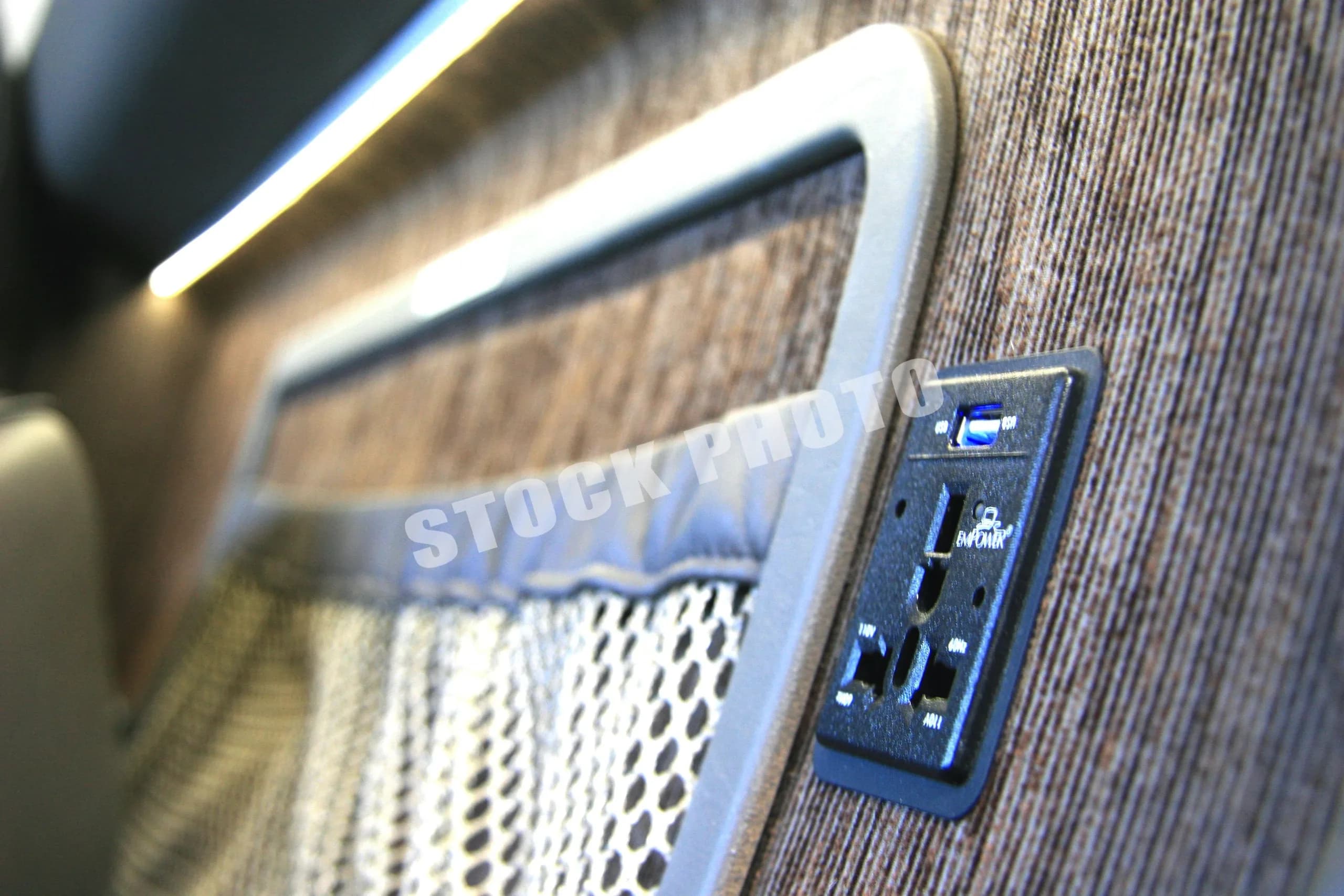 A close-up of a power outlet and USB port on the textured side panel of the Eclipse 500 cabin.