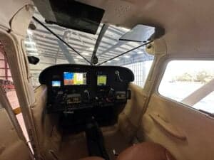 View of the cockpit of a Cessna 185 Skywagon from the cabin.