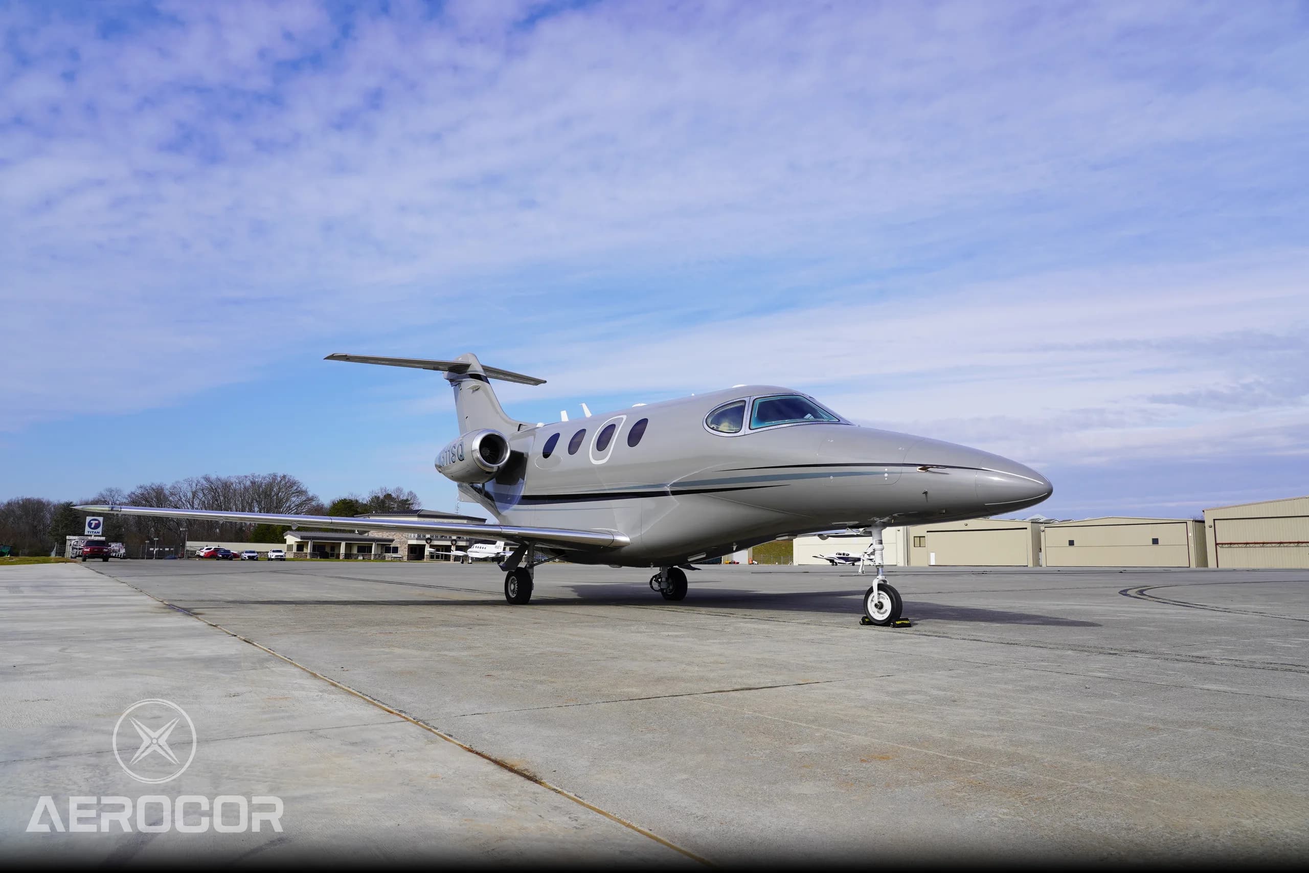 A low-angle front-side view of the gray Raytheon Premier I business jet, registration N311SQ, on a concrete ramp.