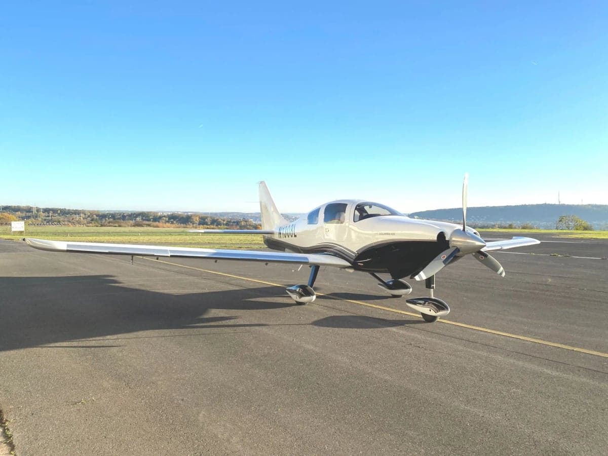 A Cirrus Columbia 400, registration N1038L, parked on the tarmac.