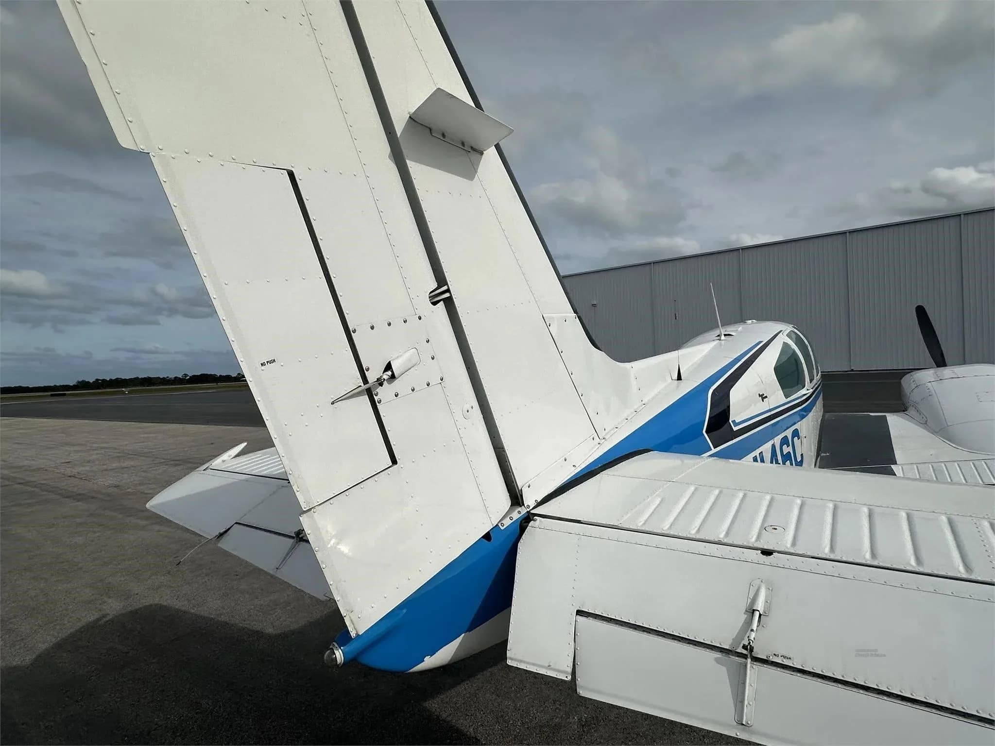 A close-up view of the tail section of the white and blue aircraft N146C.