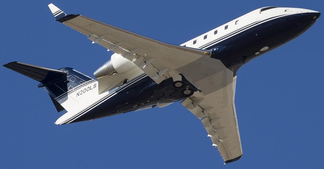 A Bombardier Challenger 300 with registration N200LS is seen from below during flight.
